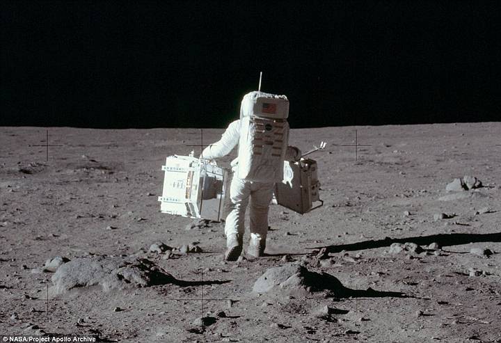 Aldrin carga equipos científicos sobre la superficie lunar para llevar a cabo experimentos sísmicos y recolectar muestras.